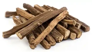 The image shows a pile of dried licorice roots. These roots are brown, with a rough, fibrous texture and are arranged in a somewhat haphazard stack. Licorice roots are often used for their sweet flavor and medicinal properties. This image is interesting and relevant because it highlights the natural form of licorice before it is processed into various products such as candies, teas, and herbal remedies. 